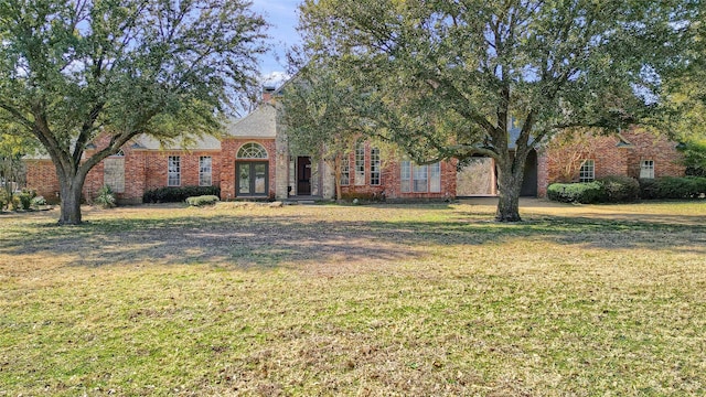 view of front of house featuring a front lawn and brick siding