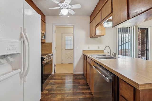 kitchen featuring ceiling fan, brown cabinets, stainless steel appliances, light countertops, and a sink