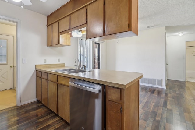 kitchen with dark wood-style floors, stainless steel dishwasher, a sink, and visible vents