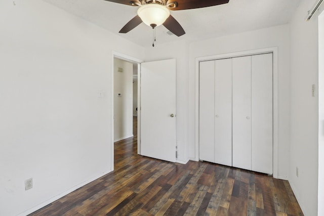 unfurnished bedroom with dark wood-style floors, ceiling fan, and a closet