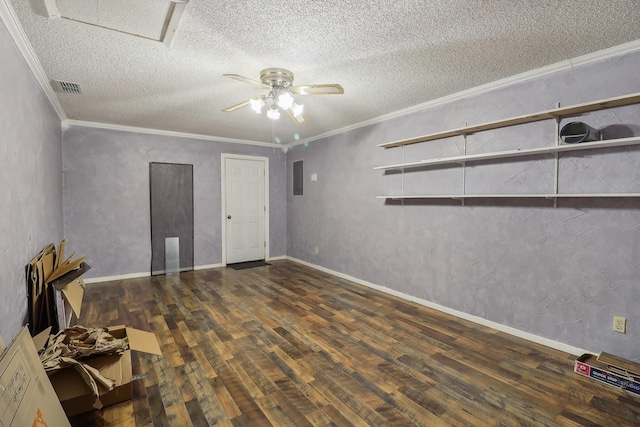 spare room with a textured ceiling, wood finished floors, visible vents, and crown molding