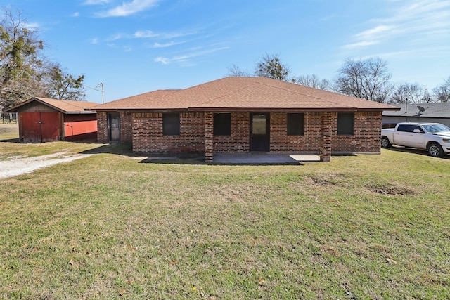 single story home with a patio area, brick siding, roof with shingles, and a front yard