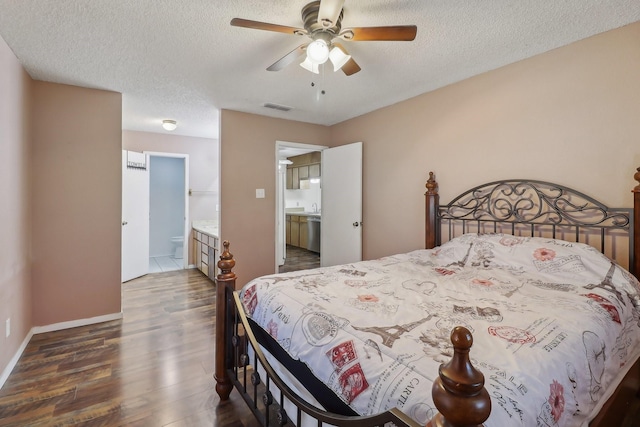 bedroom with baseboards, visible vents, wood finished floors, ensuite bathroom, and a textured ceiling