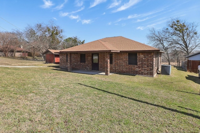 rear view of house with a yard, a patio, brick siding, and fence