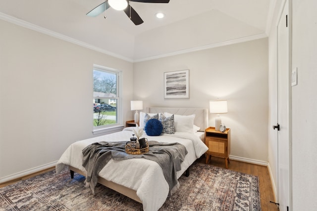 bedroom with a ceiling fan, crown molding, baseboards, and wood finished floors