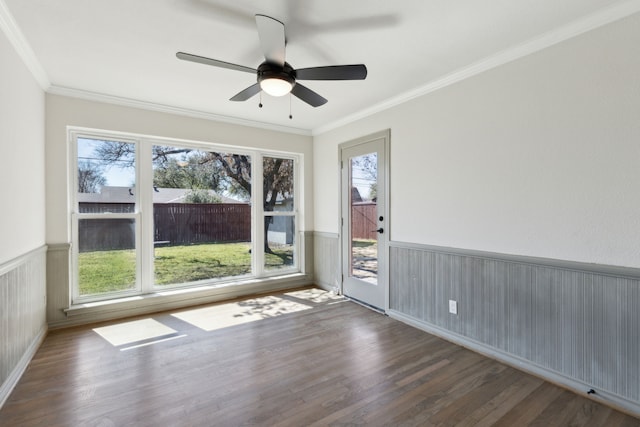 spare room featuring ceiling fan, a wainscoted wall, crown molding, and wood finished floors