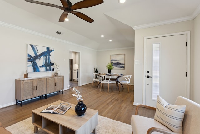 living area featuring light wood finished floors, recessed lighting, visible vents, and ornamental molding