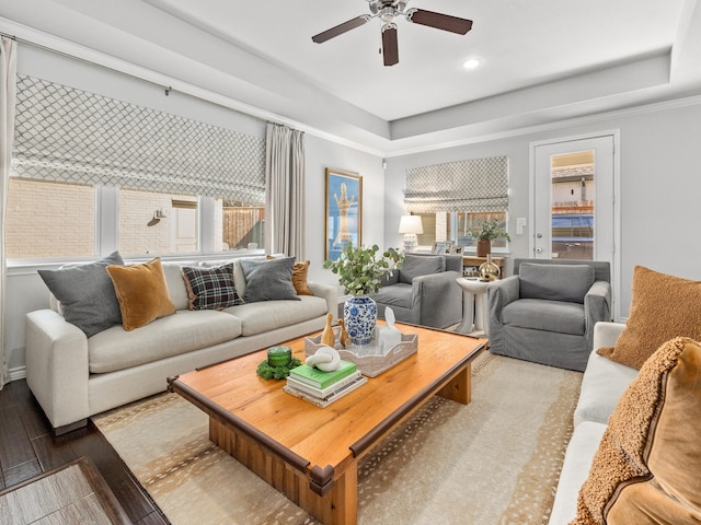 living area featuring a ceiling fan, recessed lighting, a raised ceiling, and wood finished floors