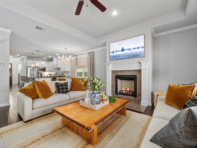 living area with ornamental molding, wood finished floors, and visible vents