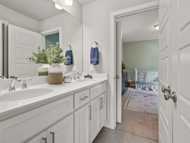 bathroom with tile patterned flooring, a sink, ensuite bathroom, and double vanity