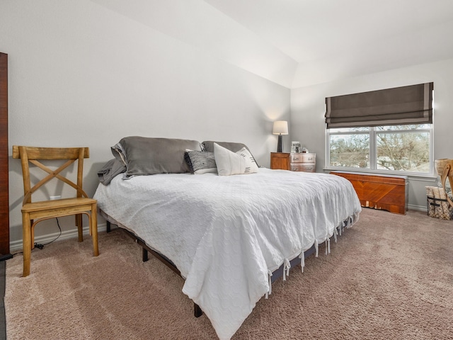 bedroom with carpet flooring, vaulted ceiling, and baseboards