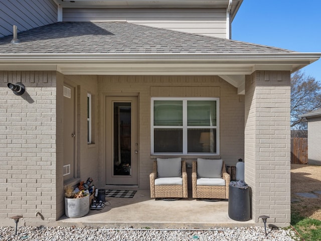 entrance to property with brick siding and roof with shingles