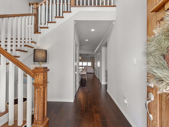 foyer with recessed lighting, wood finished floors, baseboards, stairway, and crown molding