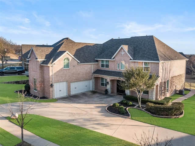 traditional-style house with concrete driveway, a front lawn, an attached garage, and brick siding