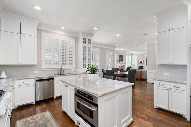 kitchen with stainless steel appliances, dark wood-style flooring, a sink, and white cabinets