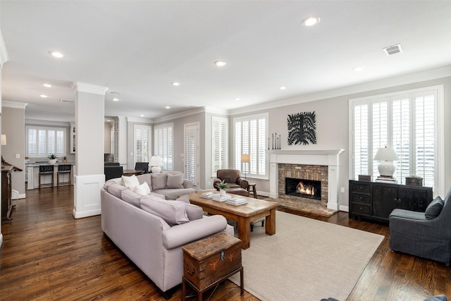 living area with visible vents, dark wood-type flooring, crown molding, ornate columns, and recessed lighting