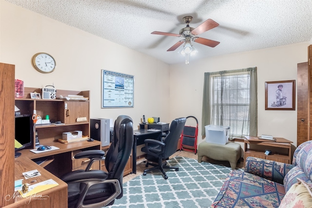 carpeted office featuring ceiling fan and a textured ceiling