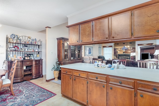 kitchen with open floor plan, light countertops, and brown cabinetry