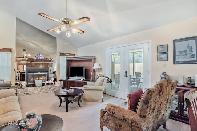 carpeted living room featuring vaulted ceiling, french doors, a brick fireplace, and a ceiling fan