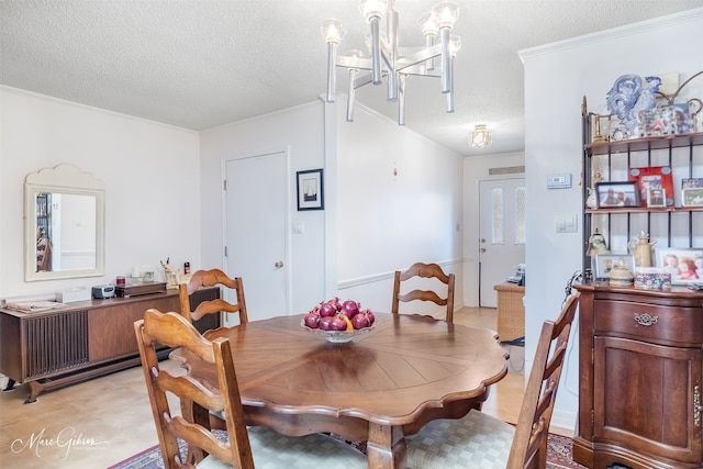 dining space featuring ornamental molding, a chandelier, and a textured ceiling