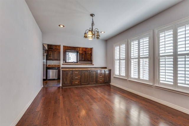 interior space with a chandelier, dark wood-type flooring, baseboards, dishwasher, and pendant lighting