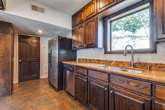 kitchen with stainless steel appliances, a sink, visible vents, and light stone countertops