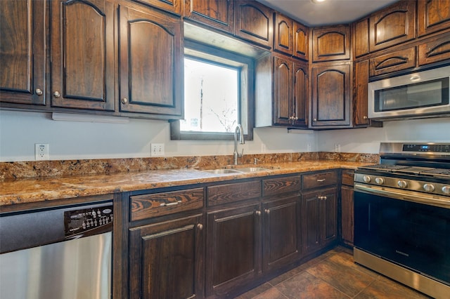 kitchen with stainless steel appliances, a sink, and dark brown cabinetry