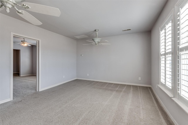 carpeted spare room with visible vents, plenty of natural light, and baseboards