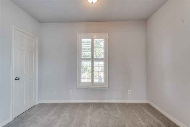 carpeted spare room with baseboards and a healthy amount of sunlight