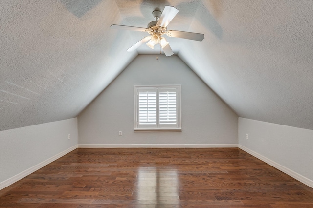 additional living space with baseboards, a ceiling fan, lofted ceiling, wood finished floors, and a textured ceiling