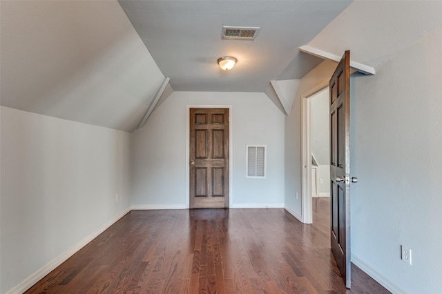 bonus room with lofted ceiling, baseboards, visible vents, and dark wood-style flooring