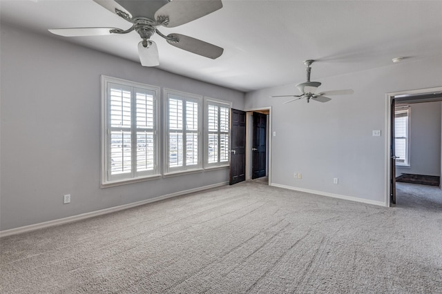 carpeted empty room with ceiling fan and baseboards