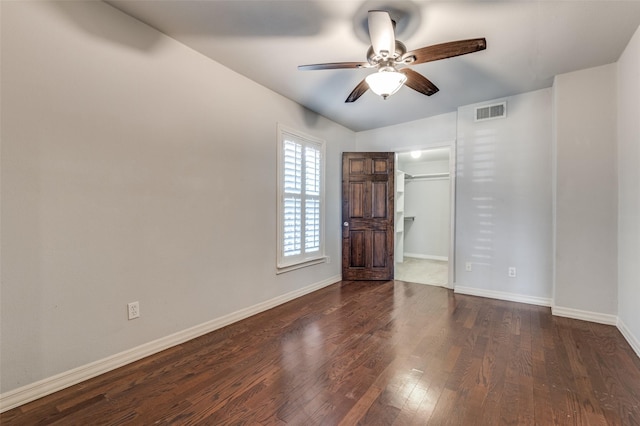 empty room featuring baseboards, visible vents, ceiling fan, and dark wood-type flooring