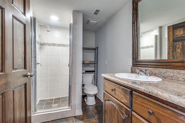 bathroom with toilet, a shower stall, visible vents, and vanity