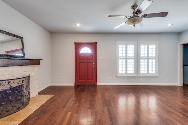 entryway featuring a stone fireplace, recessed lighting, wood finished floors, and baseboards