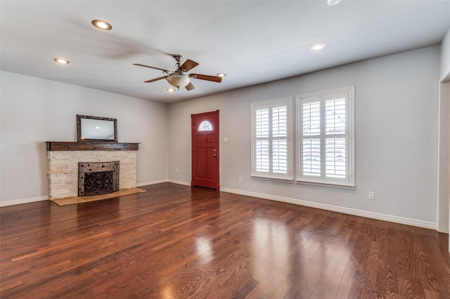 unfurnished living room with baseboards, a ceiling fan, wood finished floors, a stone fireplace, and recessed lighting