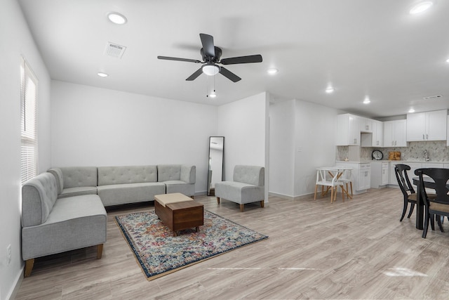 living area with light wood-style floors, baseboards, visible vents, and recessed lighting