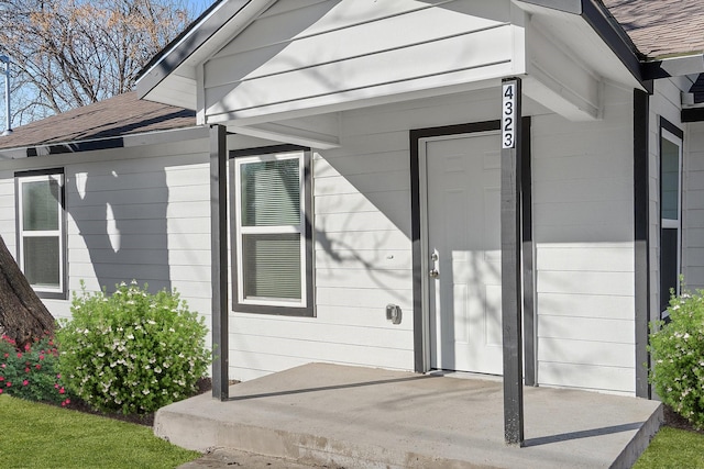 entrance to property with a shingled roof