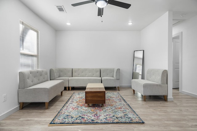 living area with light wood finished floors, recessed lighting, visible vents, and baseboards