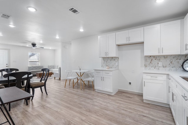 kitchen featuring light countertops, white cabinets, and visible vents