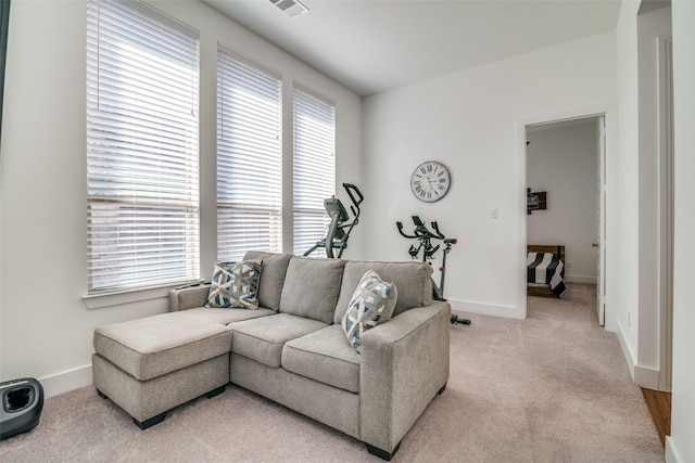 living room featuring baseboards, visible vents, and light colored carpet