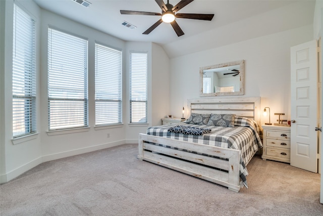 carpeted bedroom with lofted ceiling, ceiling fan, visible vents, and baseboards