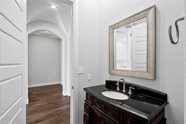 bathroom with vanity, wood finished floors, visible vents, and baseboards