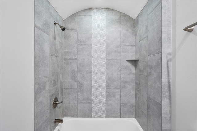 bathroom featuring vaulted ceiling and tub / shower combination