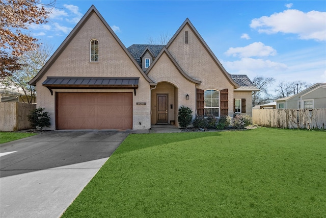 french country home with a front yard, brick siding, fence, and driveway