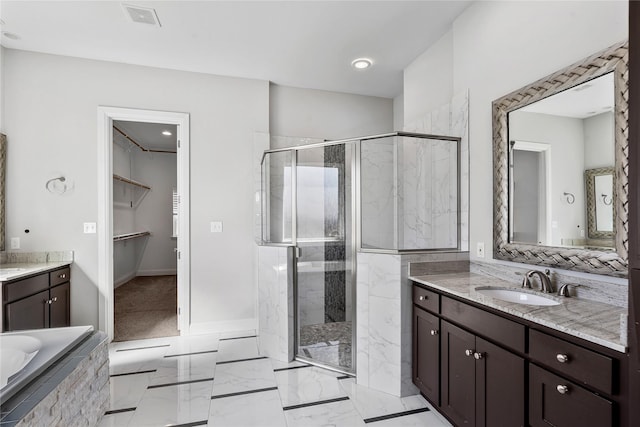 full bathroom featuring vanity, visible vents, a marble finish shower, a bath, and a walk in closet