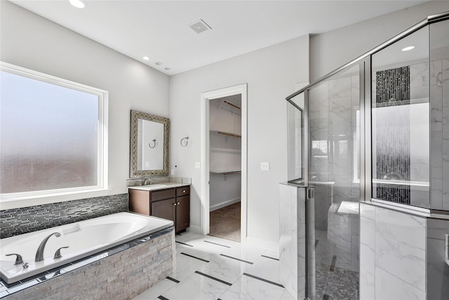 full bath with a garden tub, vanity, visible vents, a spacious closet, and a stall shower