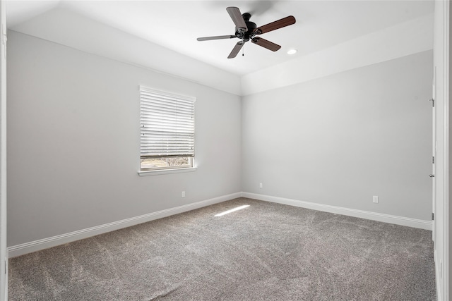 carpeted spare room with ceiling fan, baseboards, and vaulted ceiling