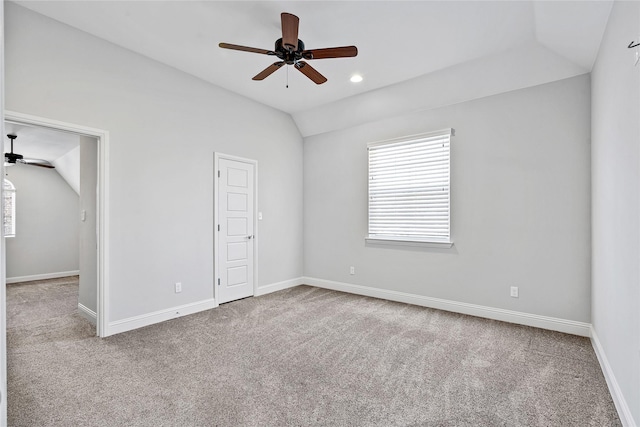 spare room with lofted ceiling, carpet floors, baseboards, and a ceiling fan