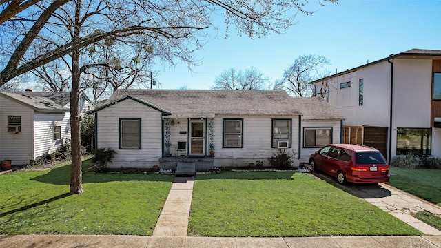 view of front facade with roof with shingles and a front yard